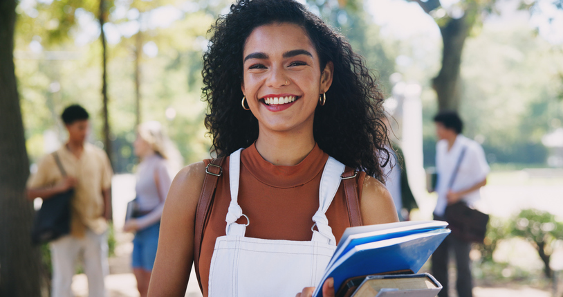 Portrait, happy woman or proud student on outdoor campus in university for opportunity or study in college. Confident, file or girl with smile, books or portfolio for school, education or scholarship How to save money on printing at SBS without cutting corners as a student